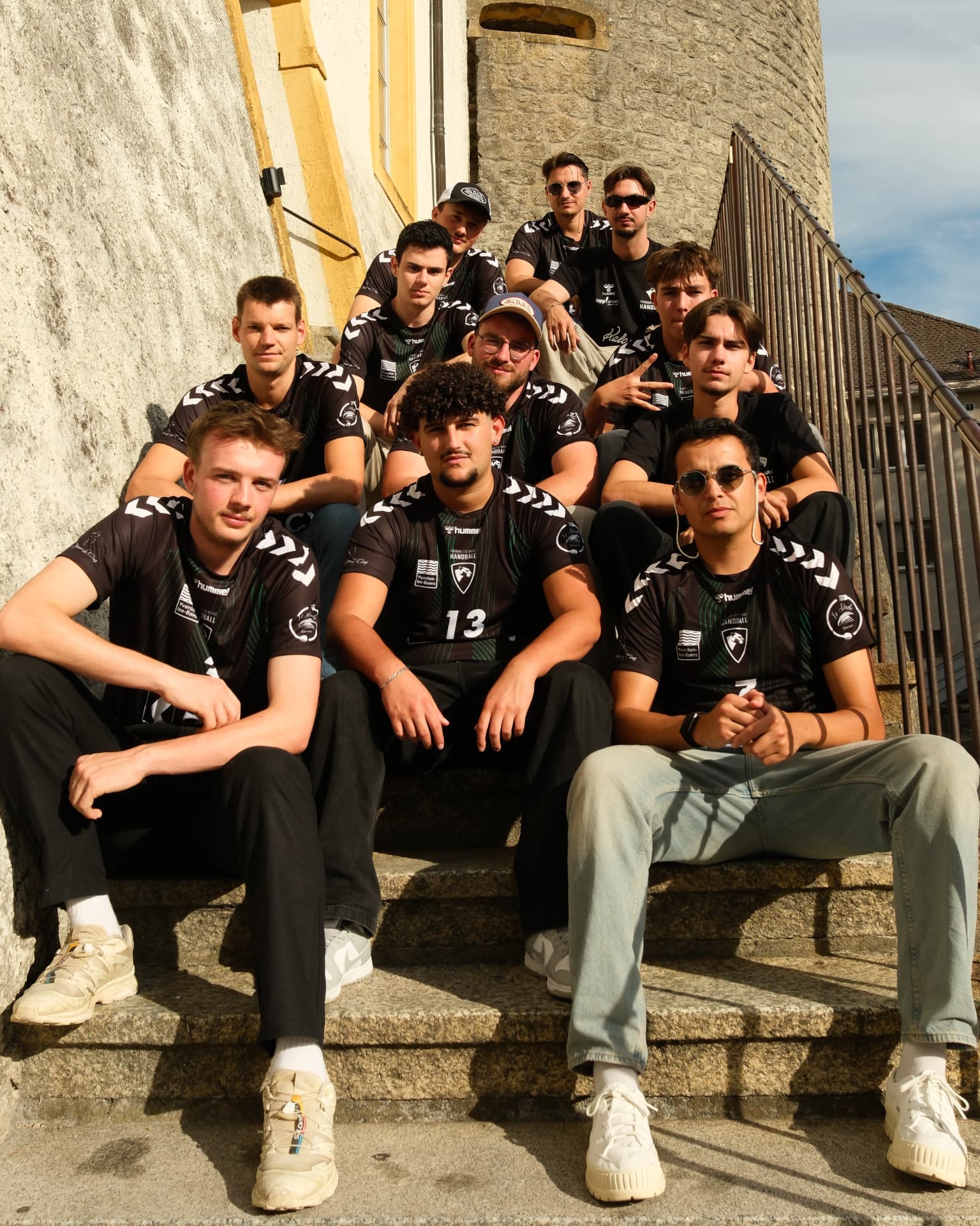 Joueurs de l'équipe Hommes 1 sur un escalier en pierre