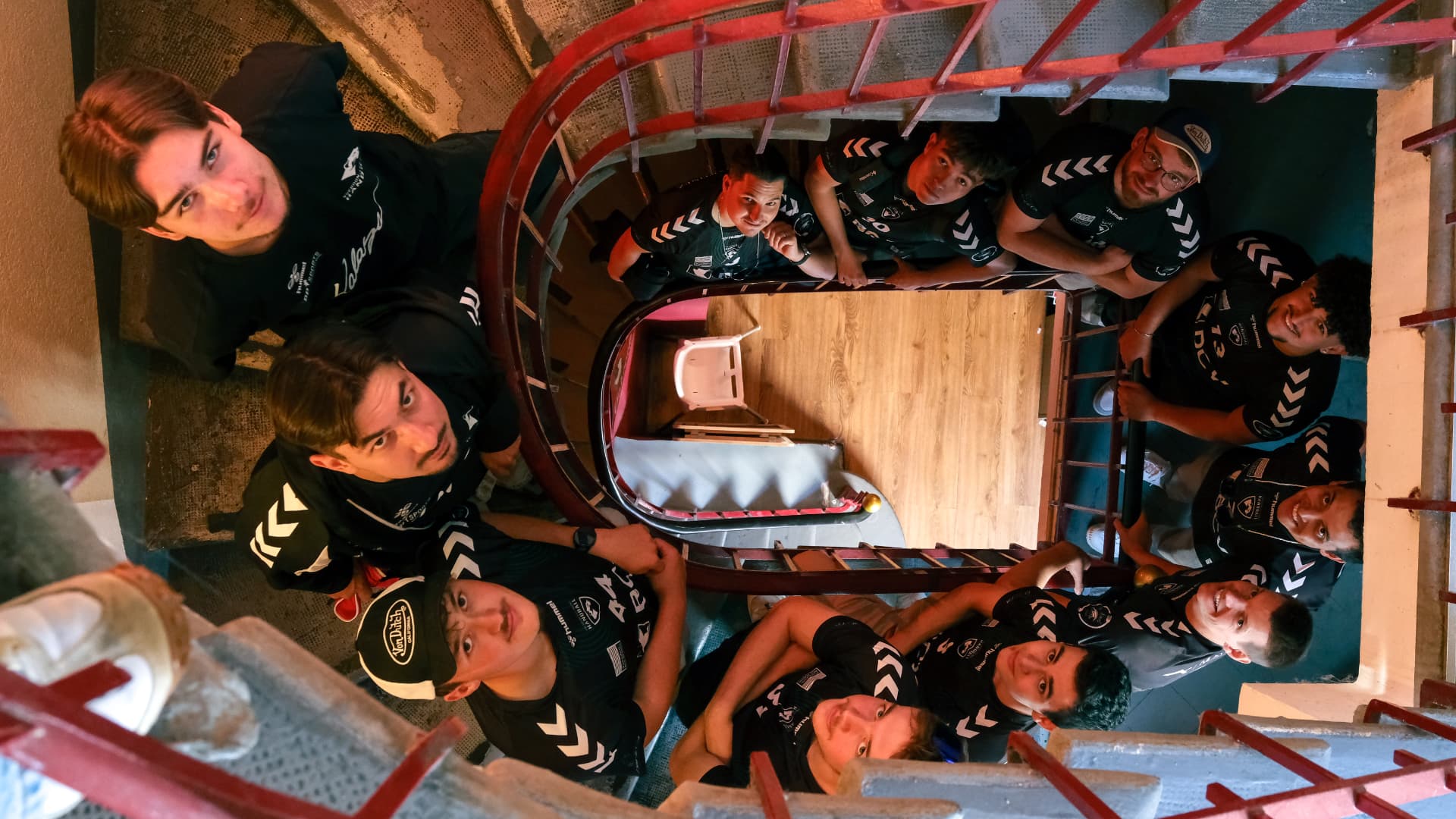 Joueurs de l'équipe Hommes 1 posant sur un escalier